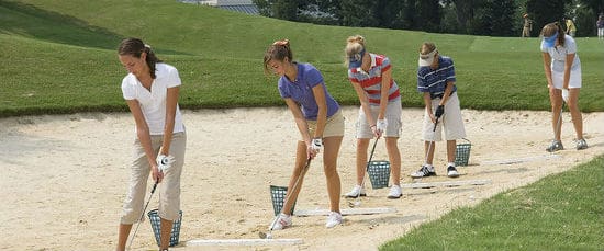 A group of people standing on top of sand.