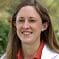 A woman in white lab coat smiling for the camera.